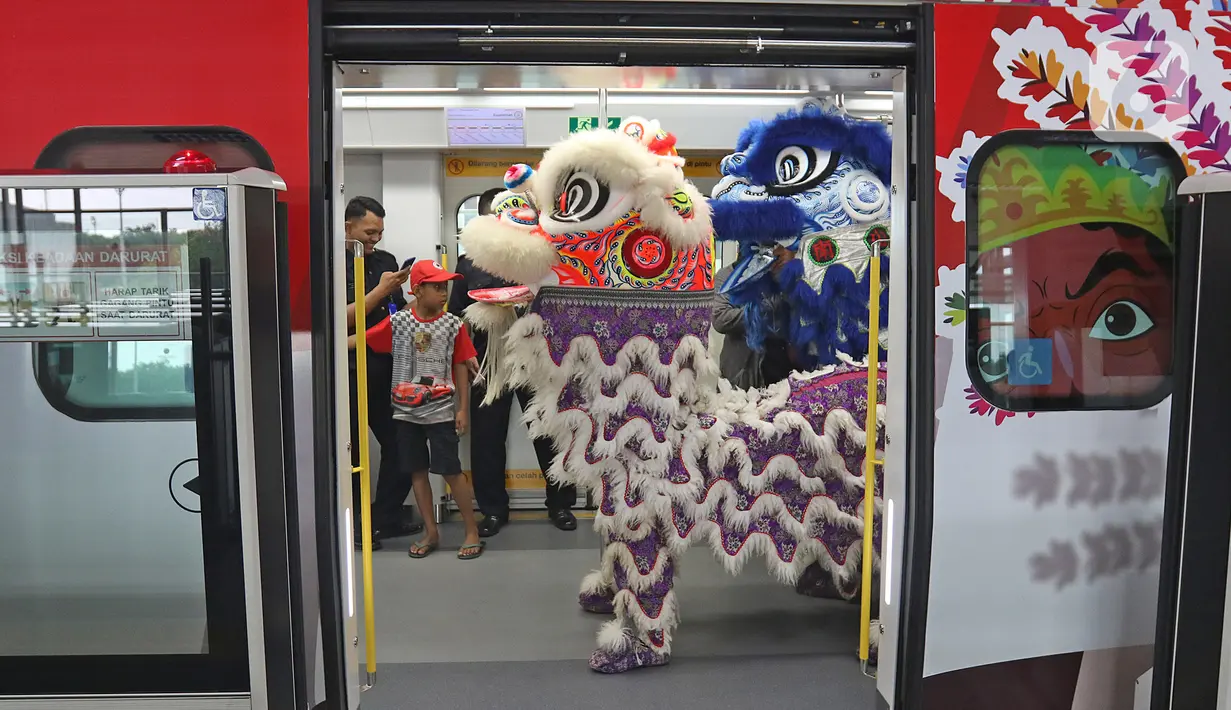 Atraksi Barongsai berkeliling untuk menghibur penumpang di Stasiun LRT Velodrome (25/1/2020). Pertunjukan tersebut dalam rangka perayaan tahun baru Imlek yang ke-2571. (Liputan6.com/Herman Zakharia)