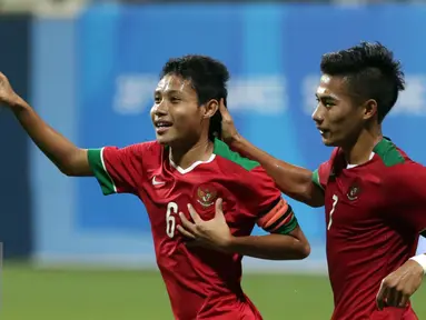 Gelandang timnas Indonesia U-23, Evan Dimas Darmono (kiri) berlari merayakan golnya ke gawang Filipina di laga penyisihan Grup A Sea Games 2015 di Stadion Jalan Besar, Singapura, Selasa (9/6/2015). Indonesia unggul 2-0. (Liputan6.com/Helmi Fithriansyah)