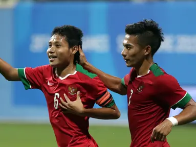 Gelandang timnas Indonesia U-23, Evan Dimas Darmono (kiri) berlari merayakan golnya ke gawang Filipina di laga penyisihan Grup A Sea Games 2015 di Stadion Jalan Besar, Singapura, Selasa (9/6/2015). Indonesia unggul 2-0. (Liputan6.com/Helmi Fithriansyah)