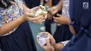 Para murid mendapat uang saat hujan uang di lapangan SMP Angkasa Halim Perdana Kusuma, Jakarta, Kamis (7/6). Hujan uang ini dalam rangka pre-launching buku milik motivator bisnis Tung Desem Waringin berjudul "LIFE REVOLUTION." (Liputan6.com/Faizal Fanani)