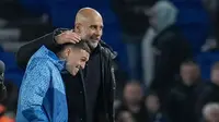 Pemain Manchester City, Phil Foden, merayakan kemenangan bersama Pep Guardiola setelah menaklukkan Brighton & Hove Albion  dalam duel tunda pekan ke-29 Liga Inggris 2024, Jumat (26/4/2024). (AP Photo/Kin Cheung)
