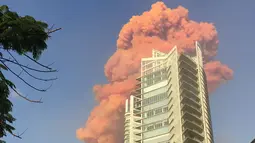 Sebuah foto yang diambil dari Teluk Zaytouna menunjukkan gumpalan api merah di belakang sebuah bangunan tinggi di pusat kota Beirut tepat setelah ledakan besar mengguncang ibukota Lebanon (4/8/2020). (AFP Photo/Bassem El Hage)