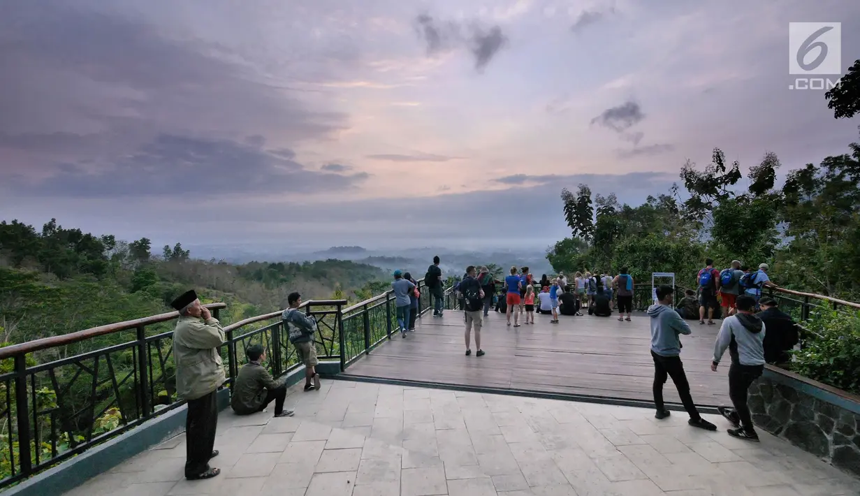 Wisatawan menyaksikan sunrise di Punthuk Setumbu, Magelang, Jawa Tengah, Jumat (19/10). Punthuk Setumbu merupakan sebuah bukit setinggi kurang lebih 400 meter dpl. (Liputan6.com/Herman Zakharia)