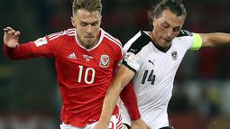 Pemain Wales, Aaron Ramsey (kiri) berebut bola dengan pemain Austria, Julian Baumgartlinger pada laga Group D kualifikasi Piala Dunia 2018 di Cardiff City Stadium, Cardiff, (2/8/2017). Wales menang 1-0. (David Davies/PA via AP)