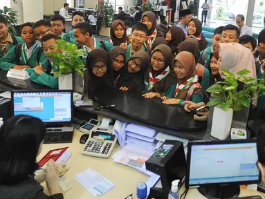 Sejumlah murid SMPN 141 menyaksikan kegiatan pelayanan perbankan di BNI Kantor Cabang Tebet, Jakarta (2/5). Kegiatan ini dalam rangka memperingati Hari Pendidikan Nasional. (Merdeka.com/Arie Basuki)