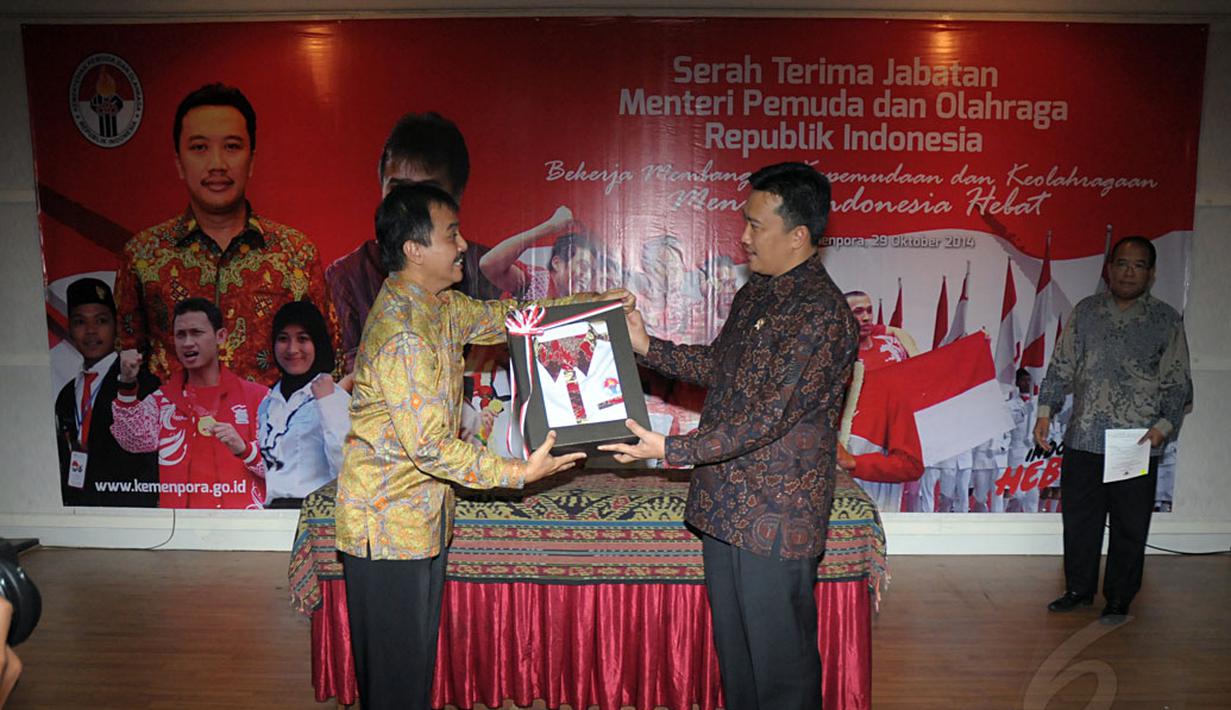 Roy Suryo (kiri) secara resmi menyerahkan seragam kantor Kementerian Pemuda dan Olahraga kepada Menpora Imam Nahrawi saat upacara serah terima jabatan di Wisma Kemenpora, Jakarta, Rabu (29/10/2014). (Liputan6.com/Helmi Fithriansyah)