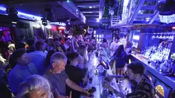 Orang-orang berkumpul di Bar Fiber di Leeds, setelah pembatasan resmi virus corona dicabut di Inggris pada tengah malam, Senin (19/7/2021). Kelab malam yang tutup sejak Maret 2020 akhirnya bisa dibuka kembali.  (Ioannis Alexopoulos/PA via AP)