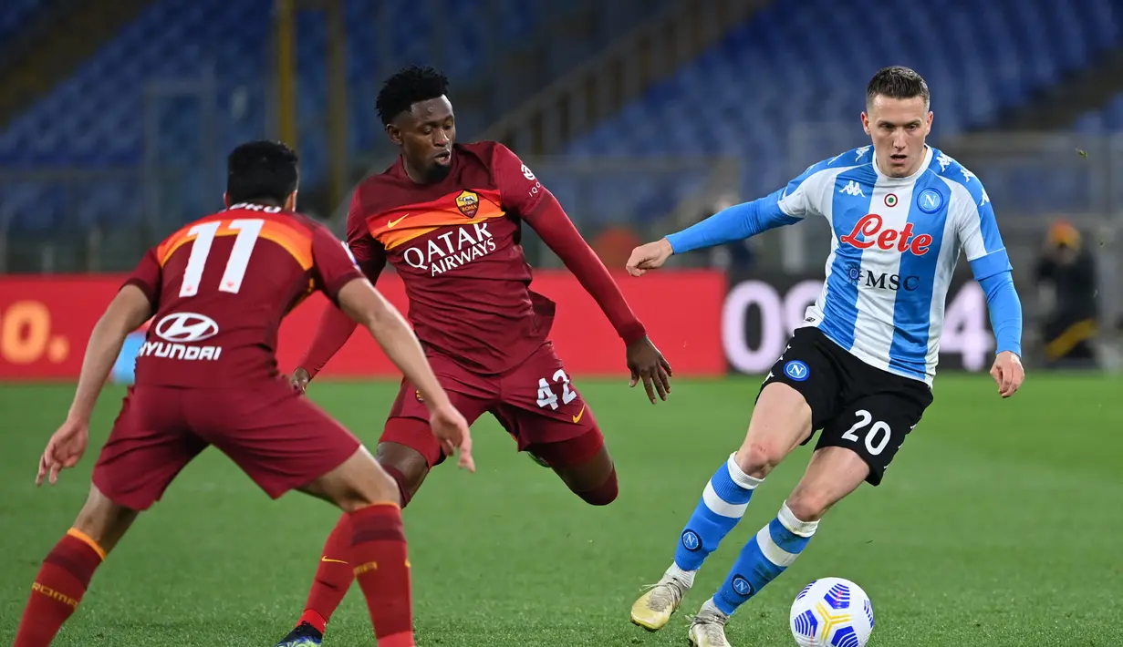 Gelandang Napoli, Piotr Zielinski berusaha melewati pemain AS Roma, Pedro dan Amadou Diawara pada pertandingan lanjutan Liga Serie A Italia di stadion Olimpiade di Roma (22/3/2021). Dengan hasil ini, Napoli mengamankan posisi lima dengan 53 poin dari 27 laga. (AFP/Alberto Pizzoli)