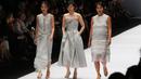 Desainer bersama dua modelnya mengenakan gaun berwarna perak saat parade desainer dalam acara pembukaan Jakarta Fashion Week 2017 di Senayan City, Jakarta, Sabtu (22/10). (Liputan6.com/Immanuel Antonius)