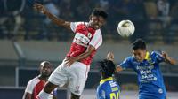 Gelandang Persib Bandung, Erwin Ramdani, duel udara dengan gelandang Persipura Jayapura, Imanuel Wanggai, pada laga Liga 1 2019 di Stadion Si Jalak Harupat, Bandung, Sabtu (18/5). Persib menang 3-0 atas Persipura. (Bola.com/M. Iqbal Ichsan)