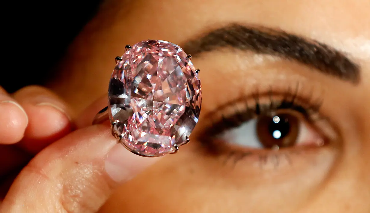 Seorang model menunjukkan cincin berlian "The Pink Star" sebelum dilelang oleh Sotheby di London, 20 Maret 2017. Berlian oval ini diprediksi akan terjual dengan harga 60 juta dollar Amerika atau sekitar Rp 799 miliar. (AP Photo/Kirsty Wigglesworth)