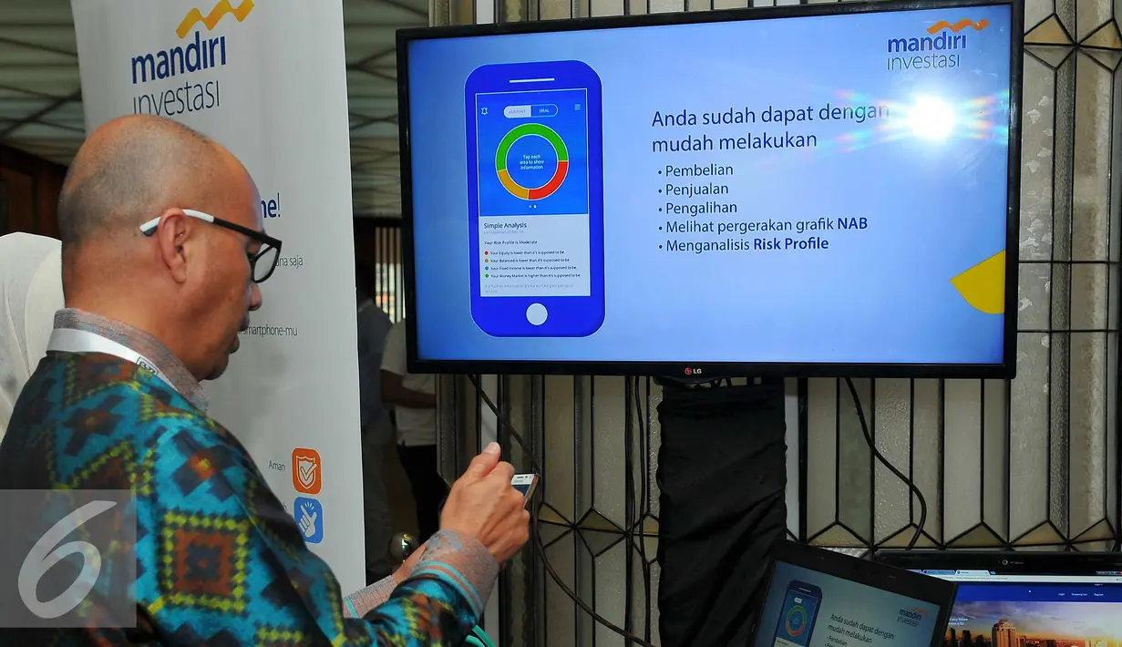 Salah satu pengunjung mencoba aplikasi saat acara Finspire di Jakarta, Rabu (9/11). Bank Mandiri juga menandatangi MoU kerjasama dengan Bukalapak.com untuk pemanfataan layanan perbankan dalam transaksi online. (Liputan6.com/Angga Yuniar)