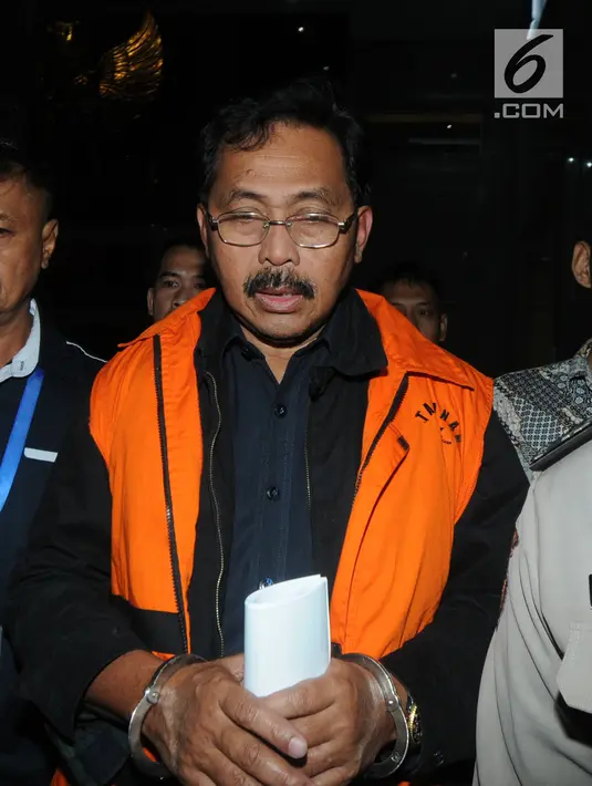 Gubernur Kepri Nurdin Basirun dikawal petugas usai menjalani pemeriksaan 1 x 24 jam di Gedung KPK, Jakarta, Jumat dini hari (12/7/2019). Nurdin Basirun resmi ditahan KPK bersama Edy Sofyan, Budi Hartono dan Abu Bakar terkait suap izin lokasi rencana reklamasi di Kepri. (merdeka.com/Dwi Narwoko)