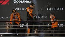 Juara F1 GP Bahrain 2025, Oscar Piastri (kiri), bersama rekan setimnya yang menempati podium ketiga, Lando Norris (tengah), dan team principal McLaren, Andrea Stella, merayakan keberhasilan tim di podium GP Bahrain, di Sirkuit Sakhir, Minggu (13/4/2025) malam WIB. (AP Photo/Altaf Qadri)