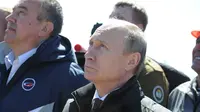 Presiden Rusia Vladimir Putin (depan) menyaksikan peluncuran roket Soyuz-2.1A dari kosmodrom Vostochny baru dalam misi membawa satelit Lomonosov, Aist-2D, dan Samsat-218 di Amur Region, Rusia, (28/4). (REUTERS/ Kirill Kudryavtsev)