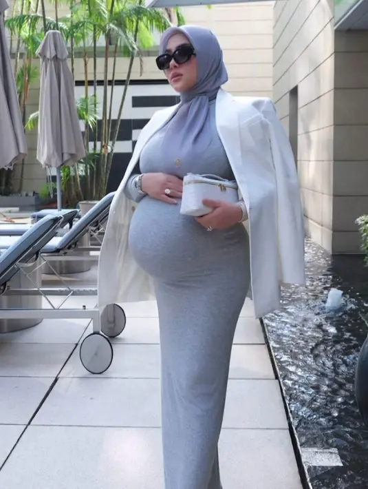 Dress tersebut dipadukan blazer putih sebagai luaran. Tak ketinggalan tas branded yang selalu ditentengnya. [@princessyahrini].