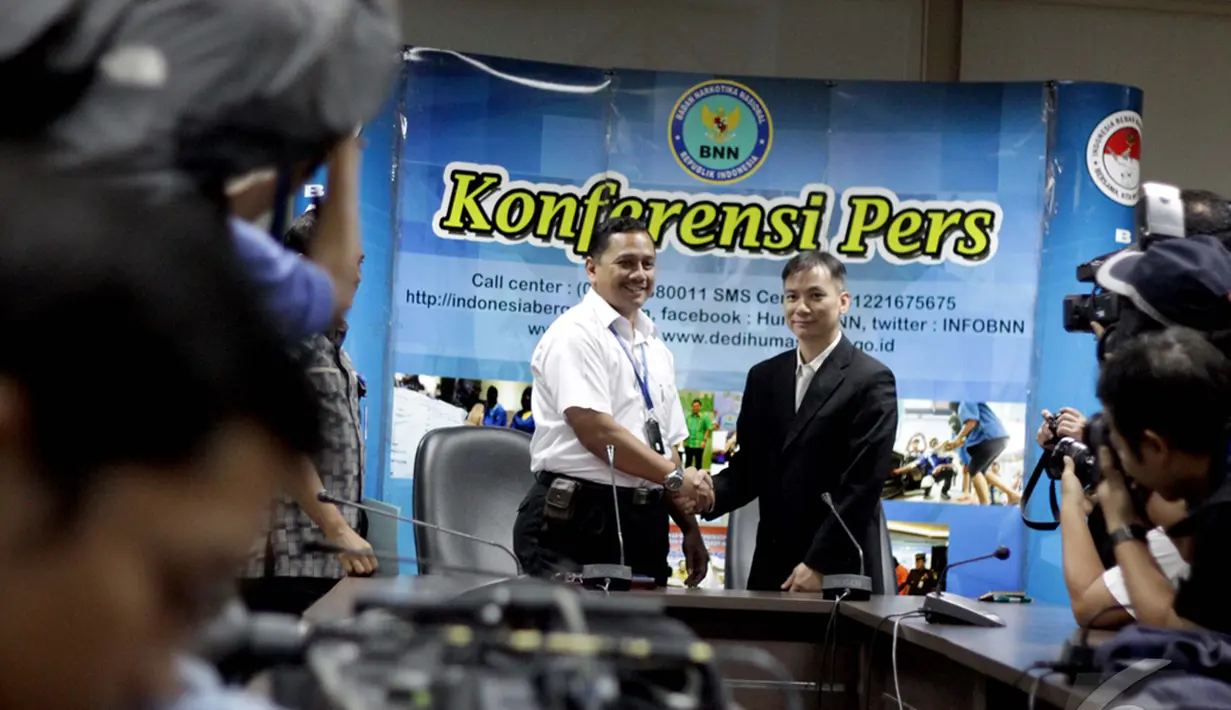 Kepala Humas BNN Sumirat Dwiyanto (tengah) bersalaman dengan perwakilan dari Kepolisian Hongkong Ko Shun-chi (kanan)  usai menggelar konfrensi pers terkait pengungkapan kasus 862 kilogram sabu, Jakarta, Kamis (15/1/2015). (Liputan6.com/Faizal Fanani)