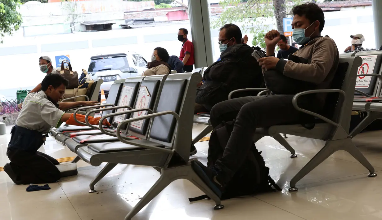 Pekerja membersihkan bangku ruang tunggu keberangkatan Stasiun Pasar Senen, Jakarta, Jumat (27/3/2020). PT Kereta Api Indonesia (Persero) membatalkan sejumlah jadwal perjalanan menyusul meluasnya penyebaran virus corona, pembatalan itu dilakukan mulai 26 Maret 2020. (Liputan6.com/Helmi Fithriansyah)