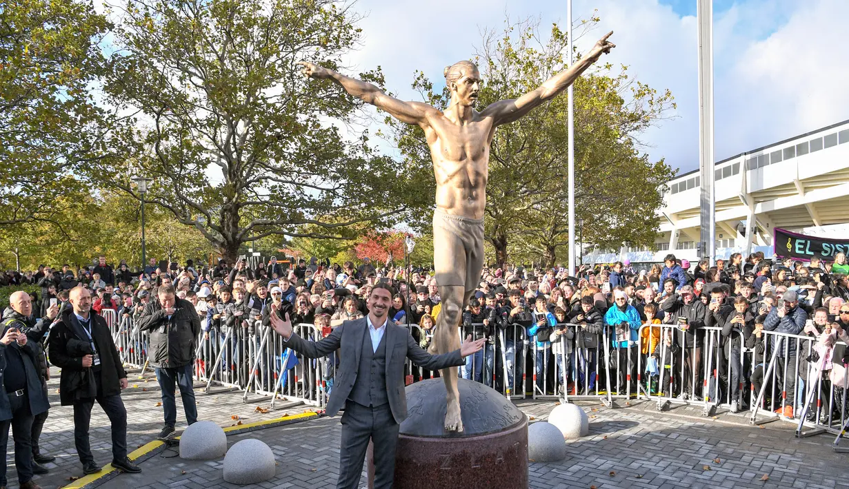 Bintang sepak bola Swedia Zlatan Ibrahimovic berpose dengan patung yang menyerupainya dekat Stadion Malmo, Malmo, Swedia, Selasa (8/10/2019). Ibrahimovic dikokohkan statusnya sebagai ikon Kota Malmo lewat sebuah patung. (Johan NILSSON/TT News Agency/AFP)