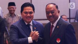 Ketua KONI Pusat Marciano Norman (kanan) berjabat tangan dengan Ketua Umum PSSI Erick Thohir (kiri) saat pengukuhan dan pelantikan pengurus PSSI masa bakti 2023-2027 di Jakarta, Jumat (26/5/2023). (Liputan6.com/Herman Zakharia)