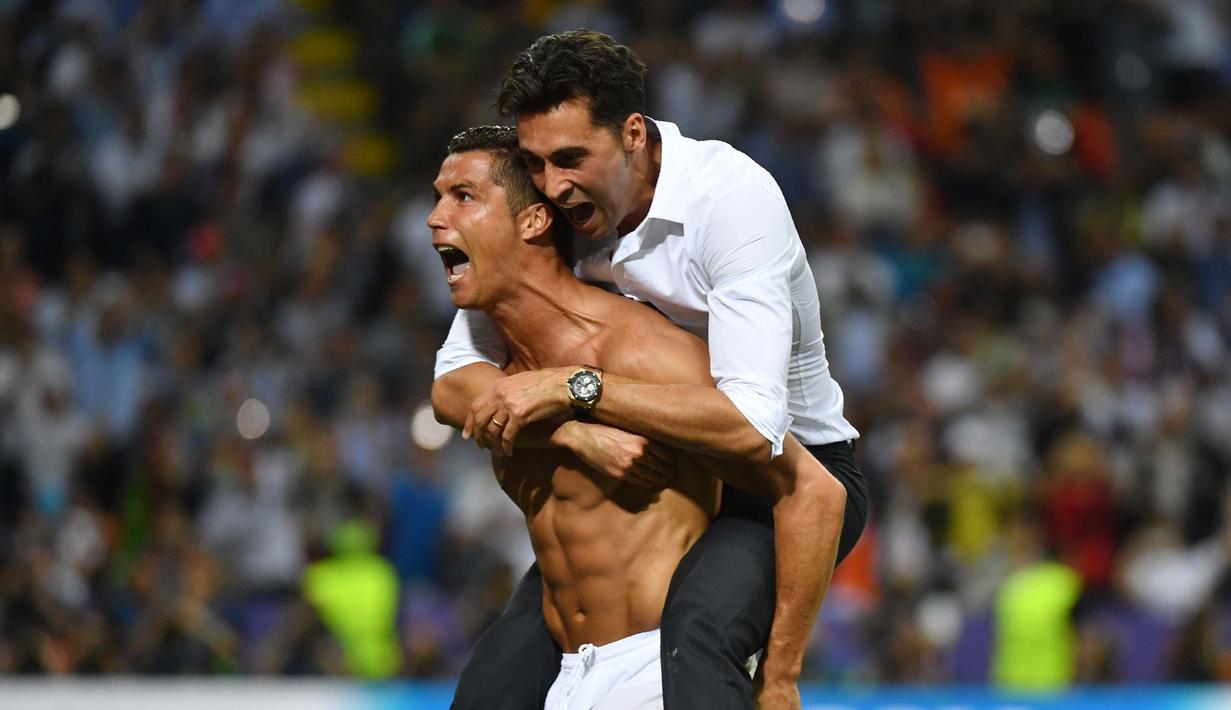 Cristiano Ronaldo menggendong salah satu staf Real Madrid saat merayakan kemenangan usai mengalahkan Atletico Madrid pada Final Liga Champions di San Siro Stadium, Milan, (29/5/2016) WIB. (AFP/Gerard Julien)