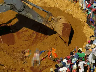 Petugas penyelamat saat mencari para korban longsor ditumpukan tanah di lokasi tambang Hpakant giok, Myanmar, (21/11). Longsor terjadi disebuah perkemahan kumuh yang berada tepat disebelah pertambangan. (REUTERS/Stringer)