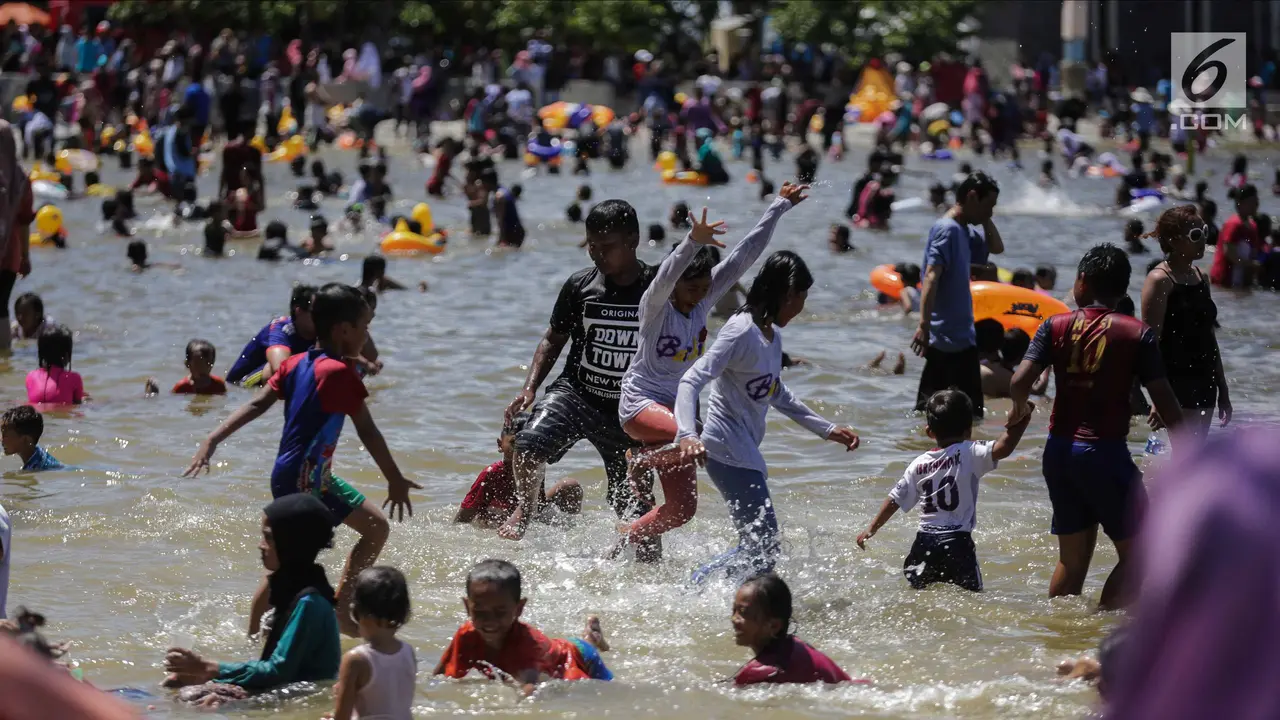 Libur Natal, Warga Menikmati Liburan Murah Meriah di Pantai Ancol