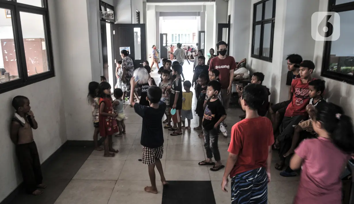 Anak-anak bermain di lorong kelas saat mengungsi di SDN 01 Kampung Melayu, Jakarta, Minggu (21/2/2021). Sudah 2 hari ratusan warga dari 4 RW di Kelurahan Kampung Melayu mengungsi di gedung sekolah lantaran banjir yang merendam rumah mereka tak kunjung surut. (merdeka.com/Iqbal S Nugroho)