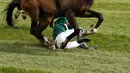 Kuda bernama Curious Carlos terjatuh saat ditunggai oleh Sean Bowen pada pacuan kuda festival nasional Crabbie Grand Liverpool, Inggris, Kamis (7/4/2016). Joki kuda ini terjatuh usai melewati pagar rintangan akhir. (Reuters / Andrew Boyers)
