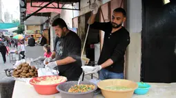 Seorang pekerja Palestina membagikan makanan gratis pada hari keempat Ramadan di Deir al-Balah, Jalur Gaza tengah, pada 27 April 2020. Warga Palestina merayakan Ramadan, bulan suci umat Islam, di tengah situasi ekonomi yang memburuk akibat pandemi COVID-19. (Xinhua/Rizek Abdeljawad)