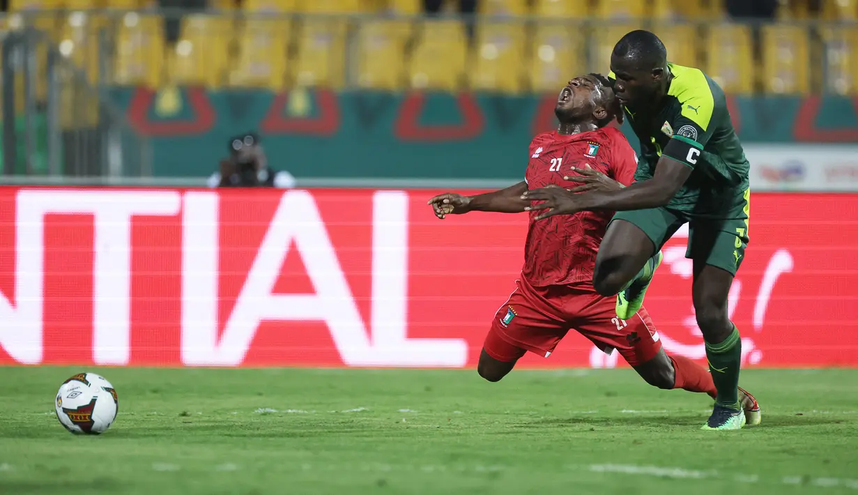 Penyerang Guinea Ekuatorial Pedro Oba (kiri) terjatuh saat berebut bola dengan bek Senegal Kalidou Koulibaly selama pertandingan perempat final Piala Afrika (CAN) 2021 di Stade Ahmadou Ahidjo di Yaounde (31/1/2022). Senegal menang atas Guinea Ekuatorial 3-1. (AFP/ Kenzo Tribouillard)