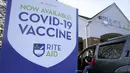 Seorang perempuan parkir di dekat tanda vaksin COVID-19 ketika dirinya tiba di apotek Rite Aid, di Nashua, New Hampshire pada 7 Desember 2021. Ketika AS mencapai tonggak sejarah dengan sekitar 200 juta orang telah divaksinasi penuh, infeksi dan rawat inap justru melonjak. (AP Photo/Steven Senne)