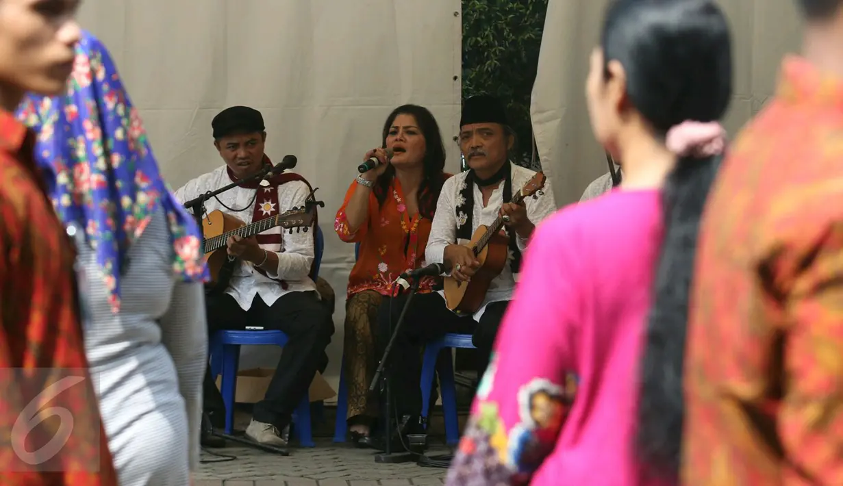 Vokalis dari kelompok Keroncong Tugu melantunkan lagu di TPS 04 Gambir, Jakarta Pusat, Rabu (19/4). Sekelompok pemusik keroncong dihadirkan di depan TPS untuk menghibur warga yang mencoblos pada Pilkada DKI 2017. (Liputan6.com/Angga Yuniar)
