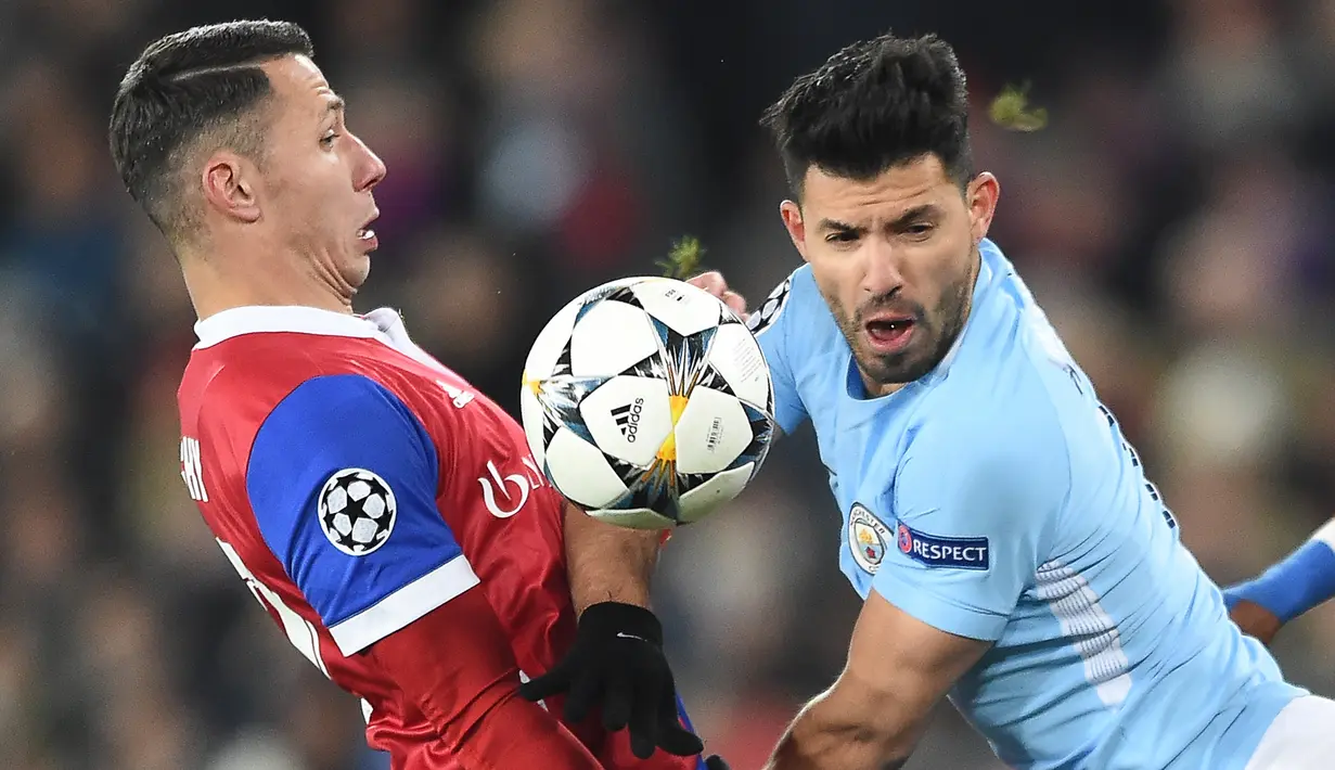 Bek FC Basel, Marek Suchy berebut bola dengan pemain Manchester City, Sergio Aguero pada leg pertama babak 16 besar Liga Champions di St. Jakob Park, Rabu (14/2). Manchester City memborong 4 gol tanpa balas kandang FC Basel. (SEBASTIEN BOZON/AFP)
