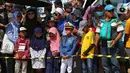 Sejumlah anak-anak antusias menyaksikan perayaan HUT ke-74 TNI di Lanud Halim Perdanakusuma, Jakarta Timur, Sabtu (5/10/2019). Warga rela panas-panasan dan berdesak-desakan untuk menyaksikan perayaan HUT ke-74 TNI. (Liputan6.com/JohanTallo)