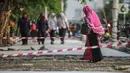 Pejalan kaki melintasi trotoar yang sedang direvitalisasi di kawasan Kramat Raya, Jakarta, Rabu (6/11/2019). Ketua Koalisi Pejalan Kaki Alfred Sitorus menilai pengerjaan revitalisasi trotoar membahayakan pejalan kaki karena tidak ada ruang sementara untuk melintas. (Liputan6.com/Faizal Fanani)