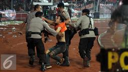 Petugas kepolisian mengamankan seorang suporter usai terlibat bentrok saat laga Persija melawan Sriwijaya FC pada lanjutan Torabika Soccer Championship presented by IM3 Ooredoo diStadion GBK Jakarta, Jumat (24/6). (Liputan6.com/Helmi Fithriansyah)