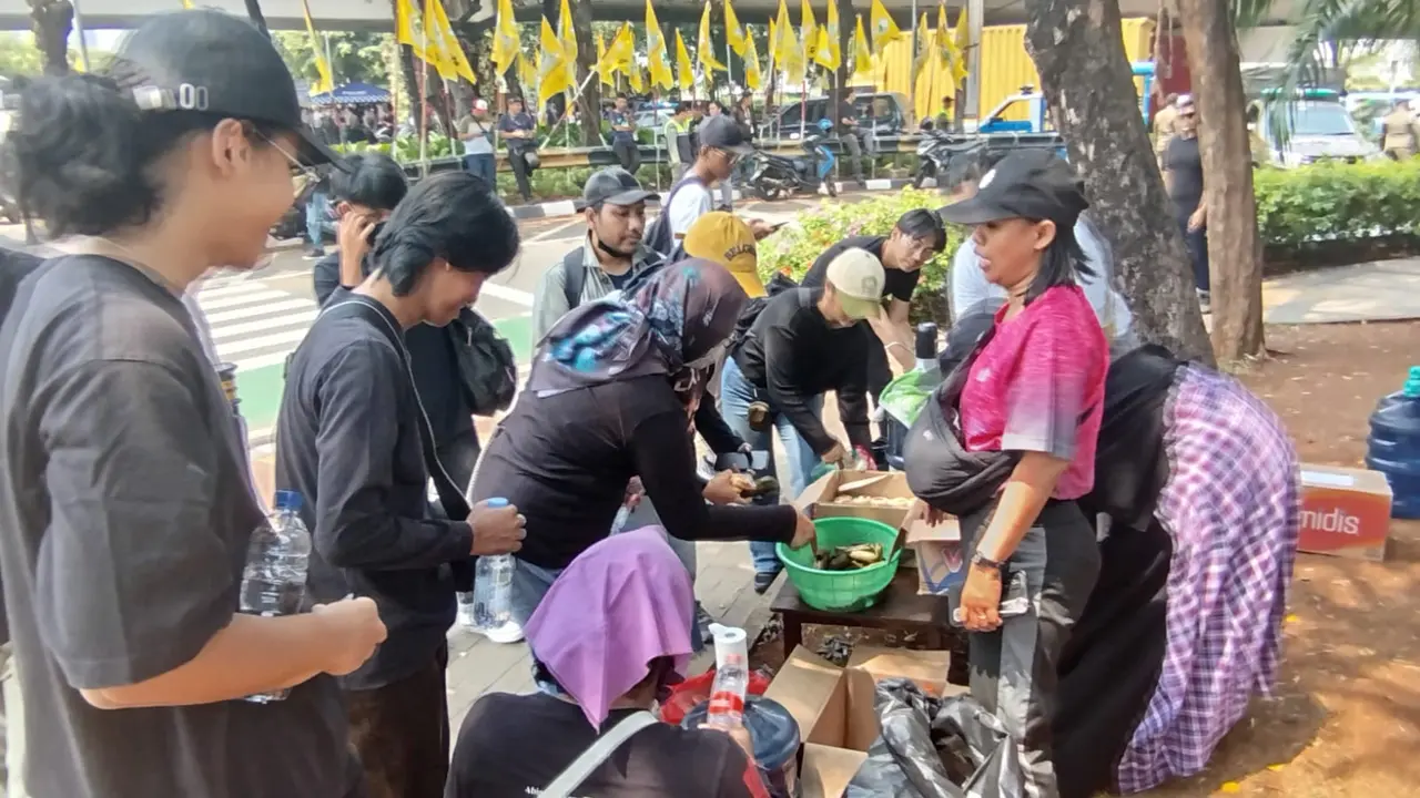 Sejumlah ibu-ibu berdiri sambil memegang karton bertuliskan "Makan dan minuman gratis". Mereka mendukung aksi massa yang mengikuti aksi peringatan darurat di depan gedung DPR, Kamis (22/8/2024).