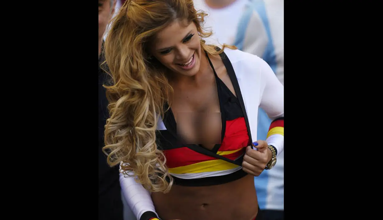 Seorang wanita mengenakan kostum warna bendera Jerman saat laga final piala dunia melawan Argentina, Senin (14/7/14). (AFP/FABRICE COFFRINI)