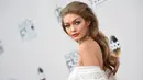 Model cantik Gigi Hadid berpose di atas karpet merah saat tiba menghadiri American Music Awards 2016 di Los Angeles, California, AS, (20/11). Gigi Hadid tampil dengan busana seksi serba putih transparan. (AFP PHOTO/Valerie Macon)