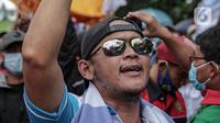 Buruh yang tergabung dalam Konfederasi Serikat Pekerja Indonesia berunjuk rasa di depan Kantor Kementerian Ketenagakerjaan, Jakarta, Rabu (16/2/2022). Buruh menuntut Permenaker Nomor 2 Tahun 2022 yang mengatur JHT baru bisa dicairkan pada usia 56 tahun segera dicabut. (Liputan6.com/Faizal Fanani)