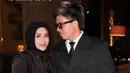 Aurel tampil tertutup elegan dalam gaun hitam berlapis detail drapery yang dipadukan dengan hijab hitam senada, menciptakan siluet anggun dan refined.
Atta memilih double-breasted black suit bergaris tipis, dipadukan dengan kacamata hitam yang memberi sentuhan maskulin dan modern. Keduanya tampak sangat seimbang yang formal, dewasa, dan classy. [@aurelie.hermansyah].