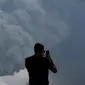 Seorang wisatawan mengabadikan gambar semburan abu vulkanik dari Gunung Bromo yang sedang erupsi di Ngadisari, Probolinggo, Jawa Timur, Selasa (5/1/2016). (REUTERS/Darren Whiteside)