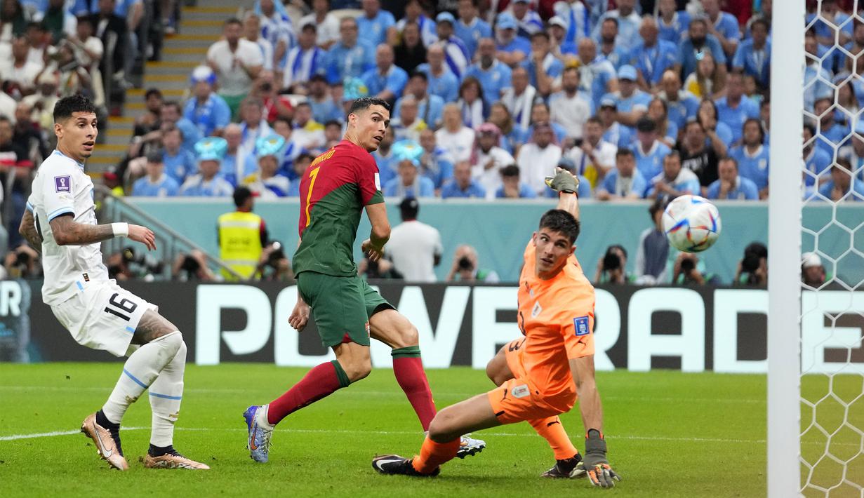 Pada proses terjadinya gol pertama, Cristiano Ronaldo berupaya menggapai umpan silang yang diberikan Bruno Fernandes dan bola akhirnya masuk ke dalam gawang Uruguay yang dijaga Sergio Rochet. (AP Photo/Petr David Josek)