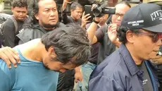 Pelaku pembunuhan sadis terhadap istri siri dan anaknya di Madiun saat digelandang ke Mapolda Jatim. (Liputan6.com/ Dok Ist)