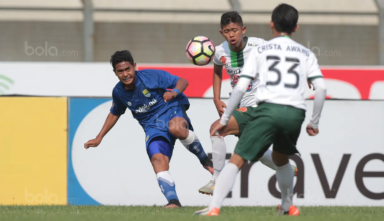 Pemain Persib Bandung U-19, Reno Saputra (kiri) melepaskan umpan melewati pemain PS TNI U-19 pada lanjutan Liga 1 2017 U-19 di Stadion Si Jalak Harupat, Sabtu (05/8/2017). (Bola.com/Nicklas Hanoatubun)