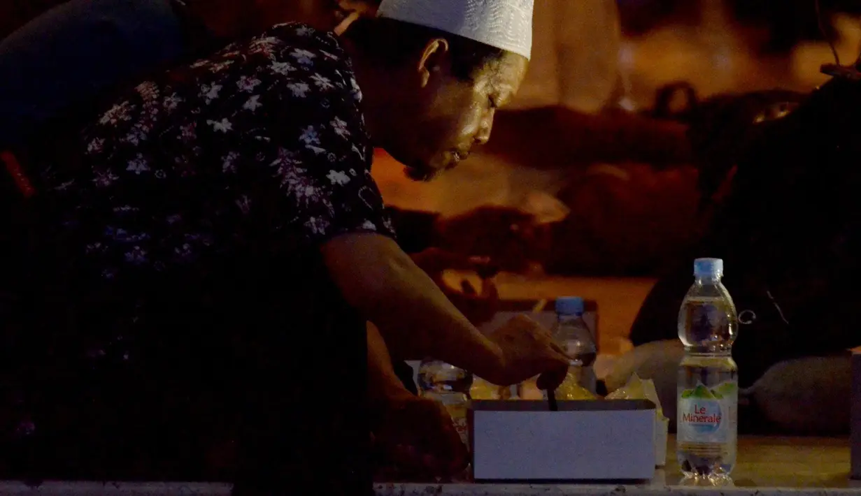 Seorang pria sedang menyantap hidangan berbuka puasa di Masjid Istiqlal. (Foto: Istimewa)