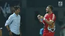 Pemain depan Persija, Marko Simic (kanan) berbincang dengan pelatih Stefano Cugurrausai kaus yang dikenakan robek pada bagian lengan saat laga melawan Selangor FA di Stadion Patriot Candrabhaga, Bekasi, Kamis (6/9). (Liputan6.com/Helmi Fithriansyah)