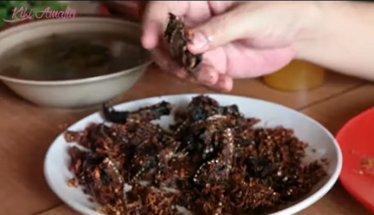 Agung menunjukkan belut pesanannya yang di goreng hingga kering. Agung mengaku lebih suka digoreng kering hingga seperti makan kerupuk. [Youtube/Kiki Amalia]