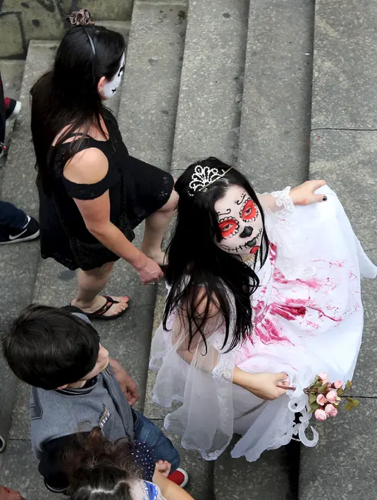 Sejumlah gadis mengenakan kostum dan berdandan seperti zombie dalam parade "Zombie Walk" di Sao Paulo, Brasil, Senin (2/11/2015). (REUTERS / Paulo Whitaker)